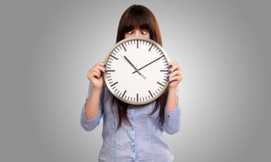 Woman Holding Clock With Squinted Eyes clipart