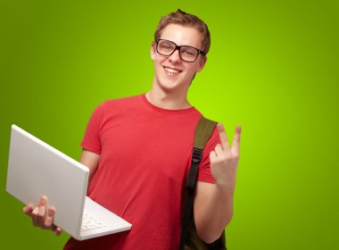 adam tutarak laptop ve sırt çantası