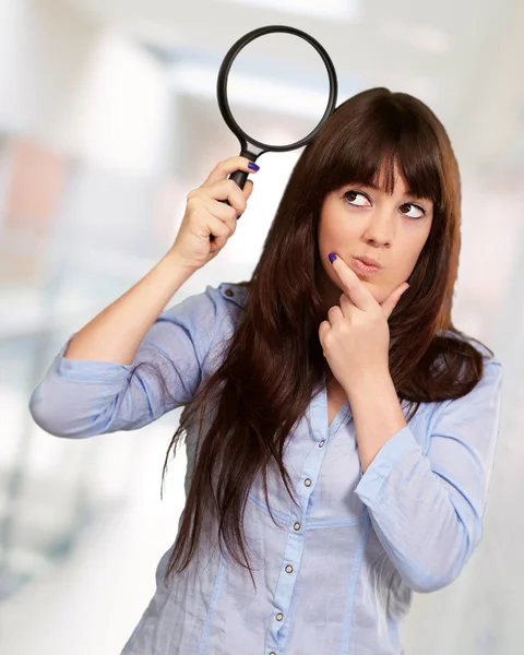 Retrato de una chica sosteniendo una lupa y pensando — Foto de Stock