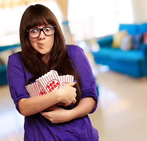 Retrato de mujer joven sosteniendo palomitas de maíz contenedor —  Fotos de Stock