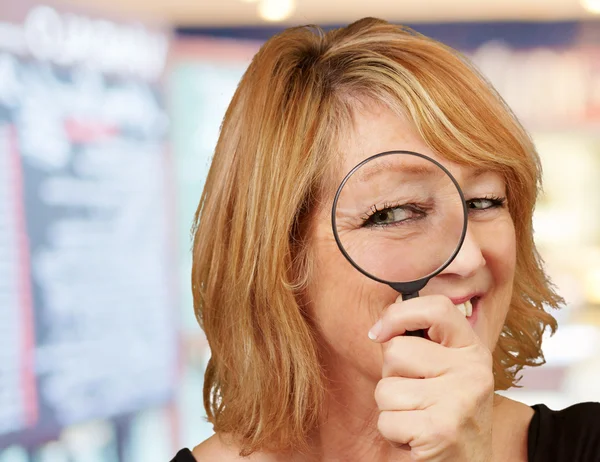 Woman looking through magnifying glass — Stock Photo, Image