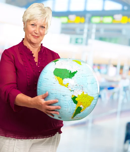 Senior vrouw bedrijf globe — Stockfoto