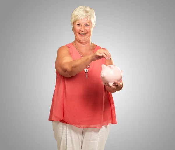年配の女性、piggybank を保持 — ストック写真