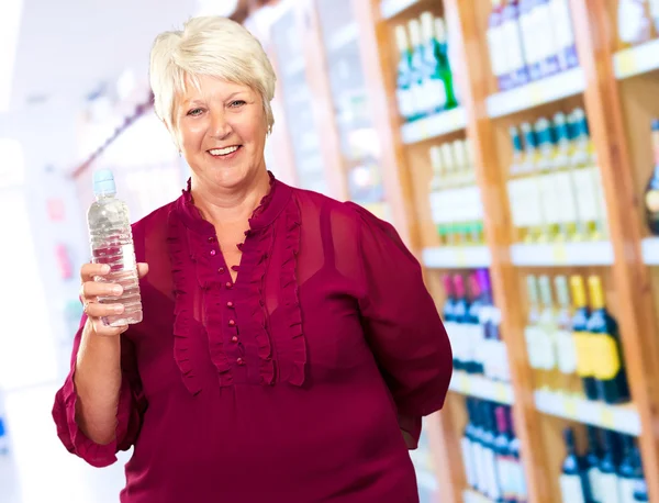 Зрелая женщина держит бутылку с водой — стоковое фото