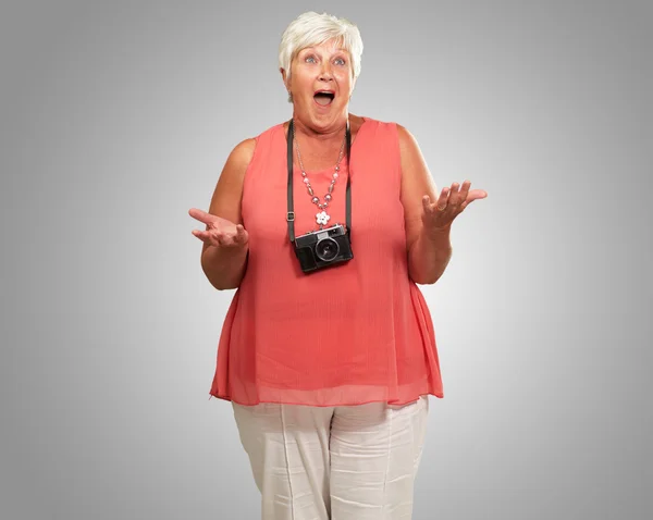 Senior mulher vestindo câmera encolhendo — Fotografia de Stock