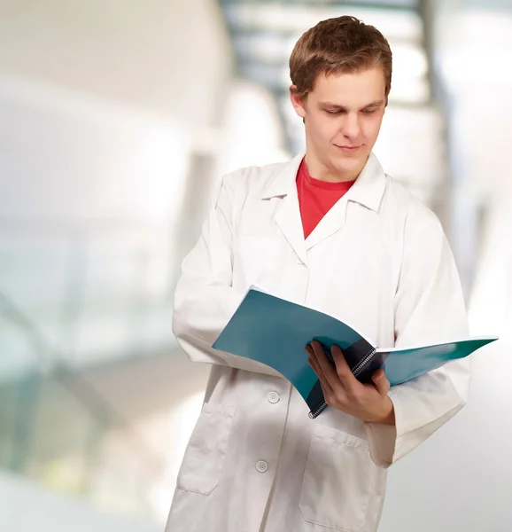 Porträt eines jungen Arztes beim Lesen einer Mappe — Stockfoto