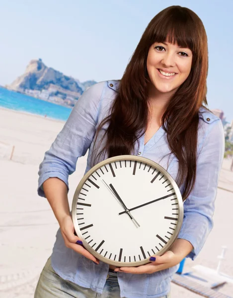 En ung flicka som håller en klocka — Stockfoto