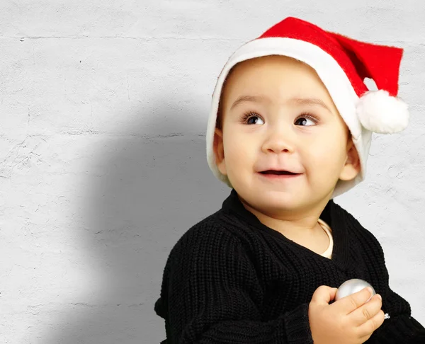 赤ちゃん男の子クリスマス帽子をかぶっていると見上げる — ストック写真