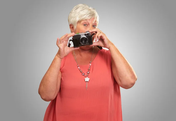Starszy kobieta gospodarstwa kamery — Zdjęcie stockowe