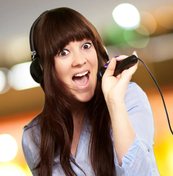 Ragazza con auricolare canto su mike — Foto Stock