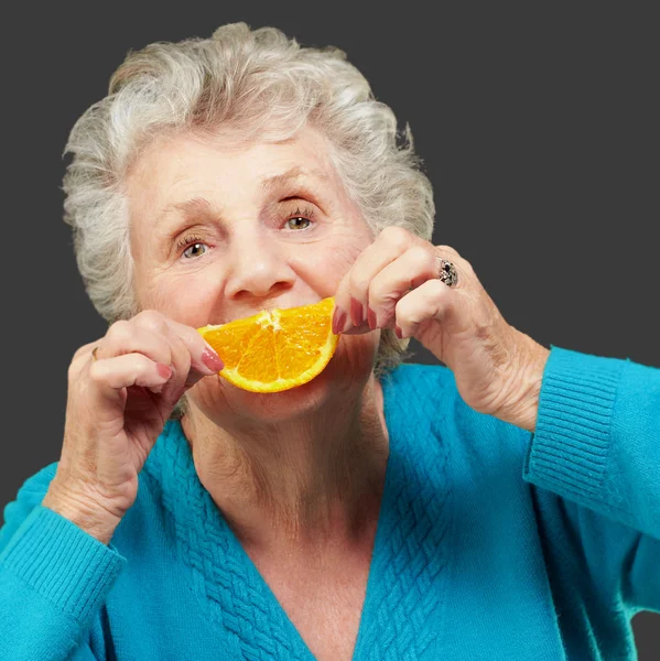 Femme mûre avec une tranche de fruit — Photo