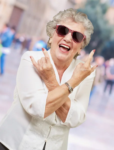 Senior mulher usando óculos de sol fazendo ação funky — Fotografia de Stock