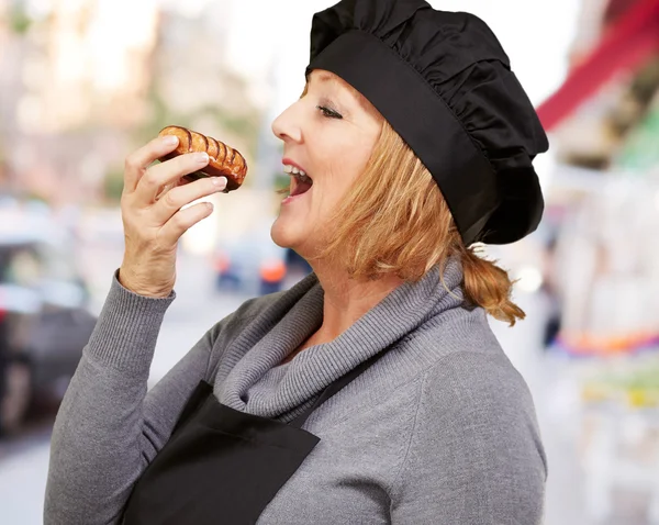 Retrato de una mujer mientras come pastelería — Foto de Stock