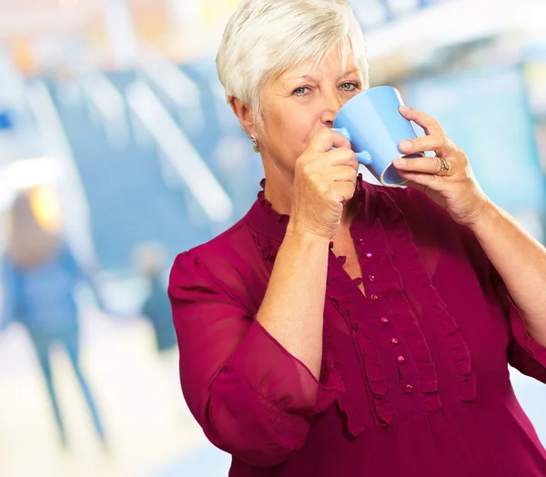 Senior vrouw drinken uit Cup — Stockfoto