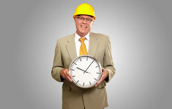 Portret van een senior man houden een muur horloge — Stockfoto