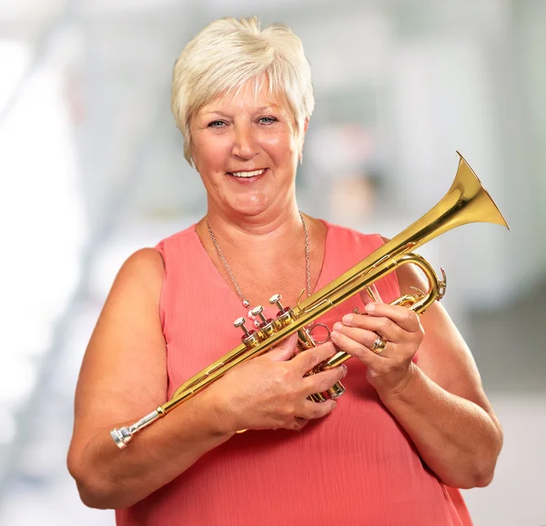 Senior mulher soprando sua trombeta — Fotografia de Stock