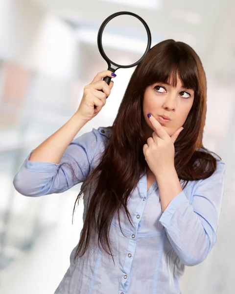 Portrait Of A Girl Holding A Magnifying Glass And Thinking Royalty Free Stock Images