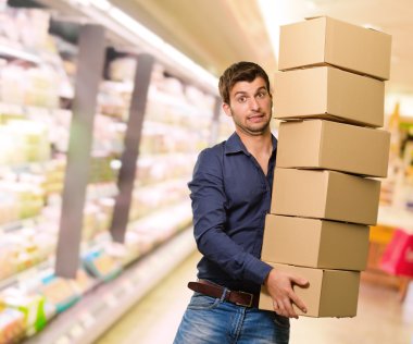 cardboxes yığını tutan genç adam