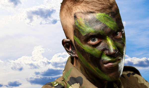 портрет солдата с камуфляжной живописью
