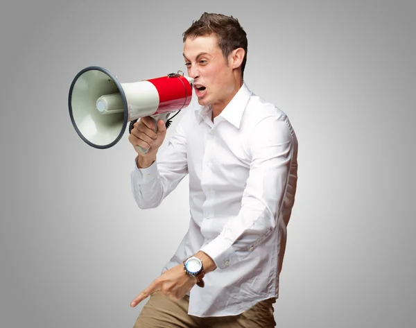 Портрет молодого человека, кричащего на мегафоне — стоковое фото