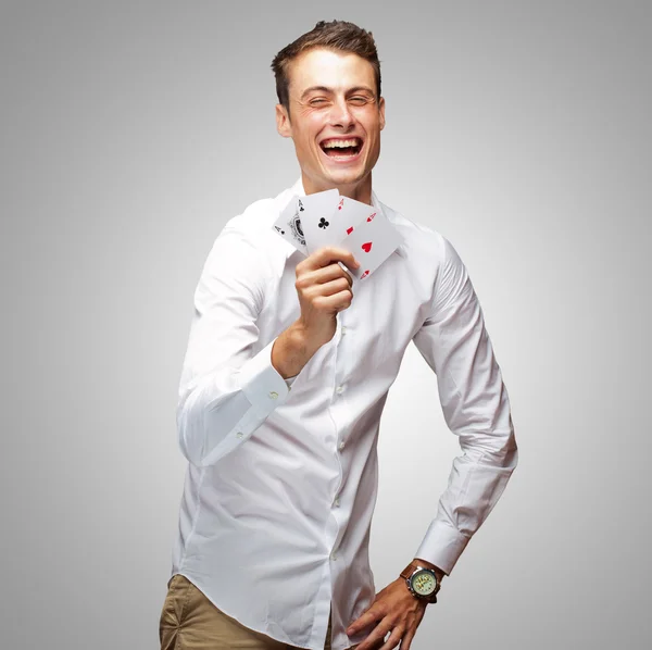 Porträt eines jungen Mannes, der Pokerkarten zeigt — Stockfoto