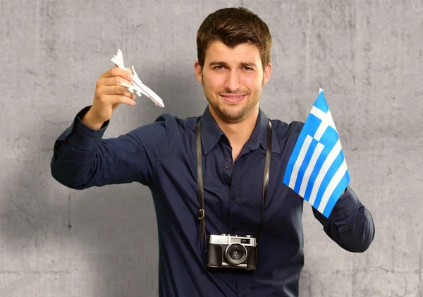 Fotografo Holding Grecia Bandiera e aereo in miniatura — Foto Stock
