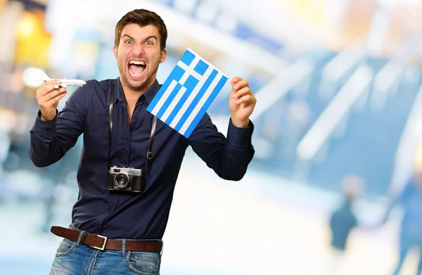 Homem segurando bandeira e avião em miniatura — Fotografia de Stock