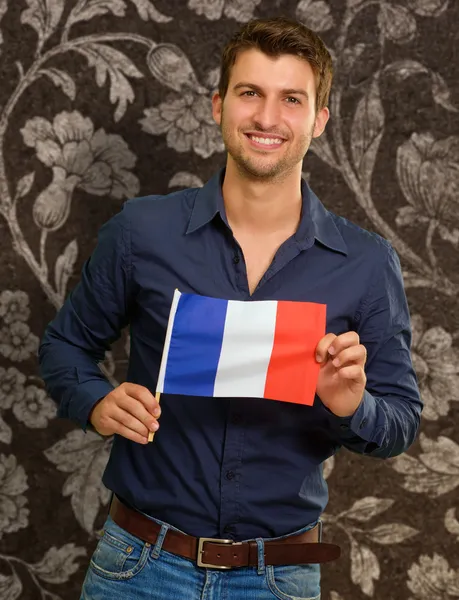 Homem jovem segurando a bandeira da França — Fotografia de Stock