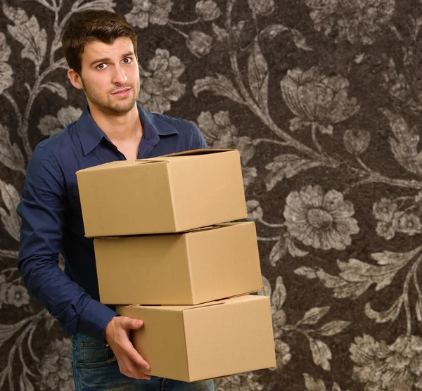 Joven hombre sosteniendo cajas de cartón — Foto de Stock