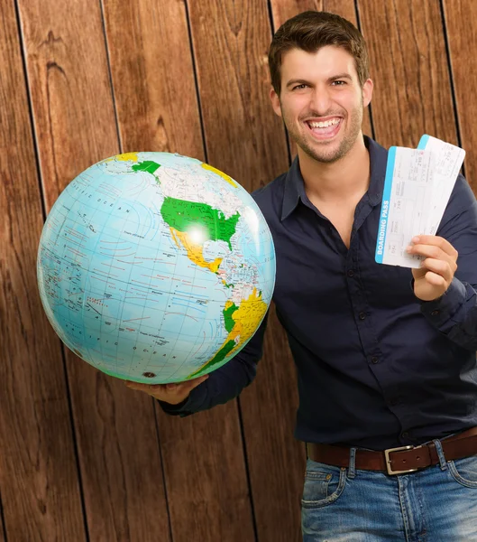 Portrait d'un jeune homme heureux avec Globe et carte d'embarquement — Photo