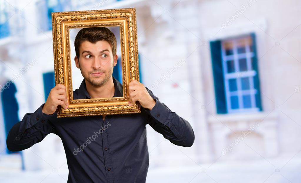 Young Man Holding Picture Frame