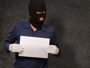 boş bir kağıt gösterilen soyguncu maskeli adam