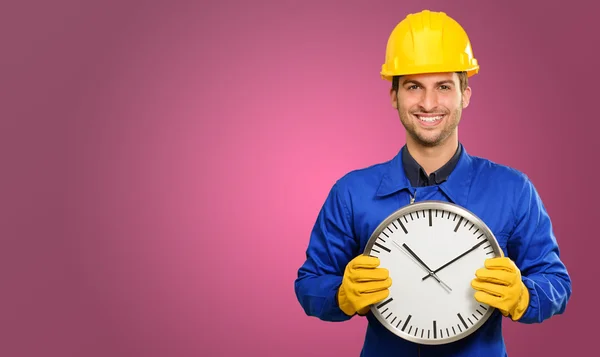 Щасливий інженер тримає настінний годинник — стокове фото
