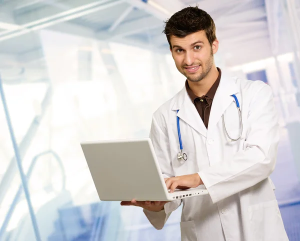 Молодой врач держит ноутбук — стоковое фото