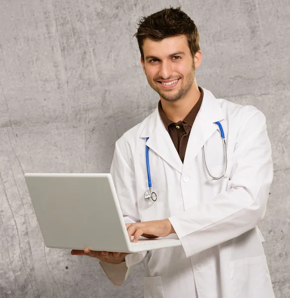 Молодой врач держит ноутбук — стоковое фото