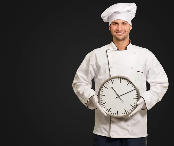 Mužský šéfkuchař drží nástěnné hodiny — Stock fotografie