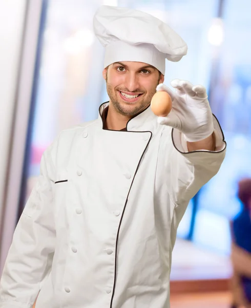 Portrét mladé šéfkuchaře drží vejce — Stock fotografie