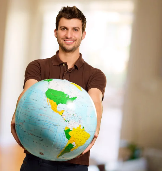 Joven sosteniendo globo — Foto de Stock