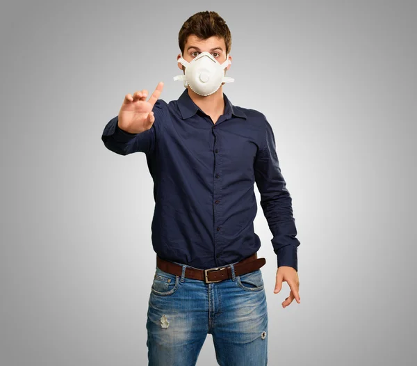 Ung man göra en gest och bär mask — Stockfoto