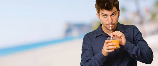 Mladý muž pití šťávy — Stock fotografie
