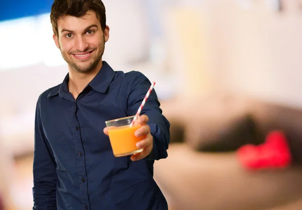 Bardak portakal suyu tutan genç adam — Stok fotoğraf