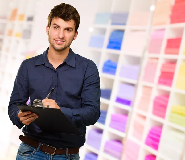 Jeune homme écrivant sur presse-papiers — Photo