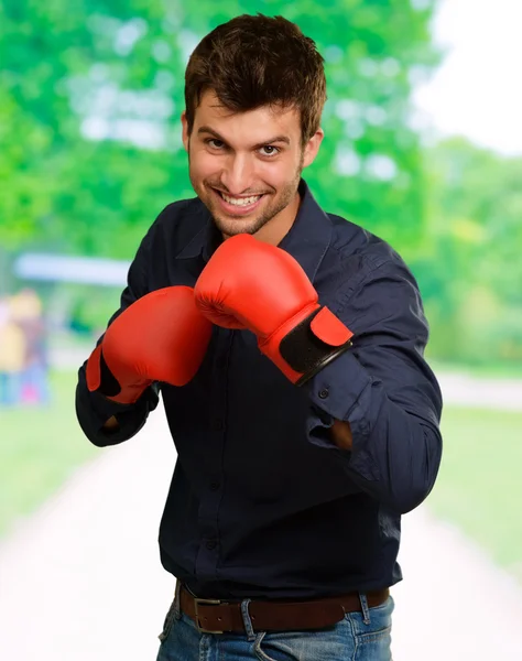 Jovem feliz vestindo luvas de boxe — Fotografia de Stock