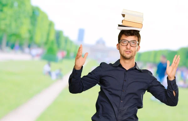 Jovem homem equilibrando livro na cabeça — Fotografia de Stock