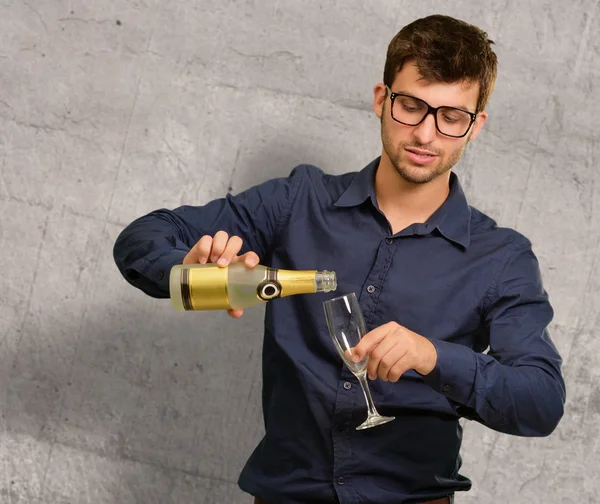 Ung man hälla champagne i glaset — Stockfoto