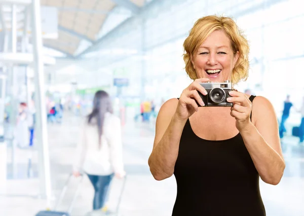 Gelukkig volwassen vrouw bedrijf camera — Stockfoto