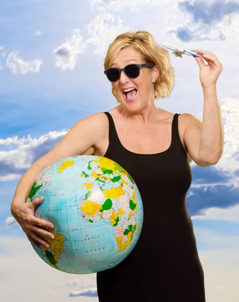 Mogen kvinna med globe och miniatyr flygplan — Stockfoto