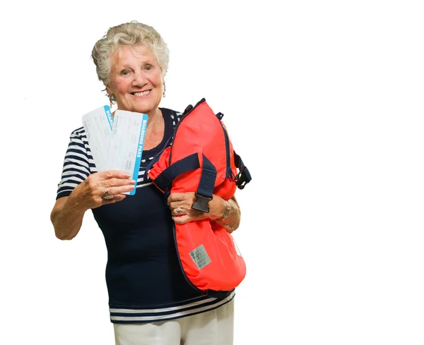 Зрелая женщина держит посадочный талон и сумку — стоковое фото