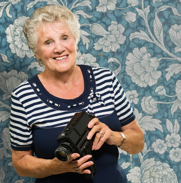 Senior mulher segurando câmera — Fotografia de Stock