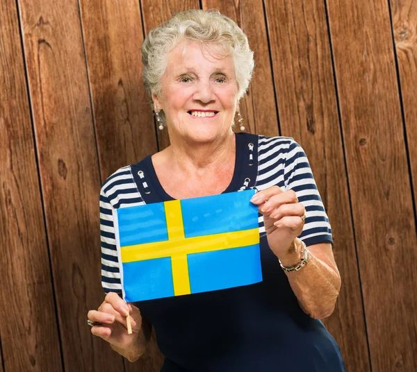 Mujer mayor feliz sosteniendo bandera de Suecia — Foto de Stock